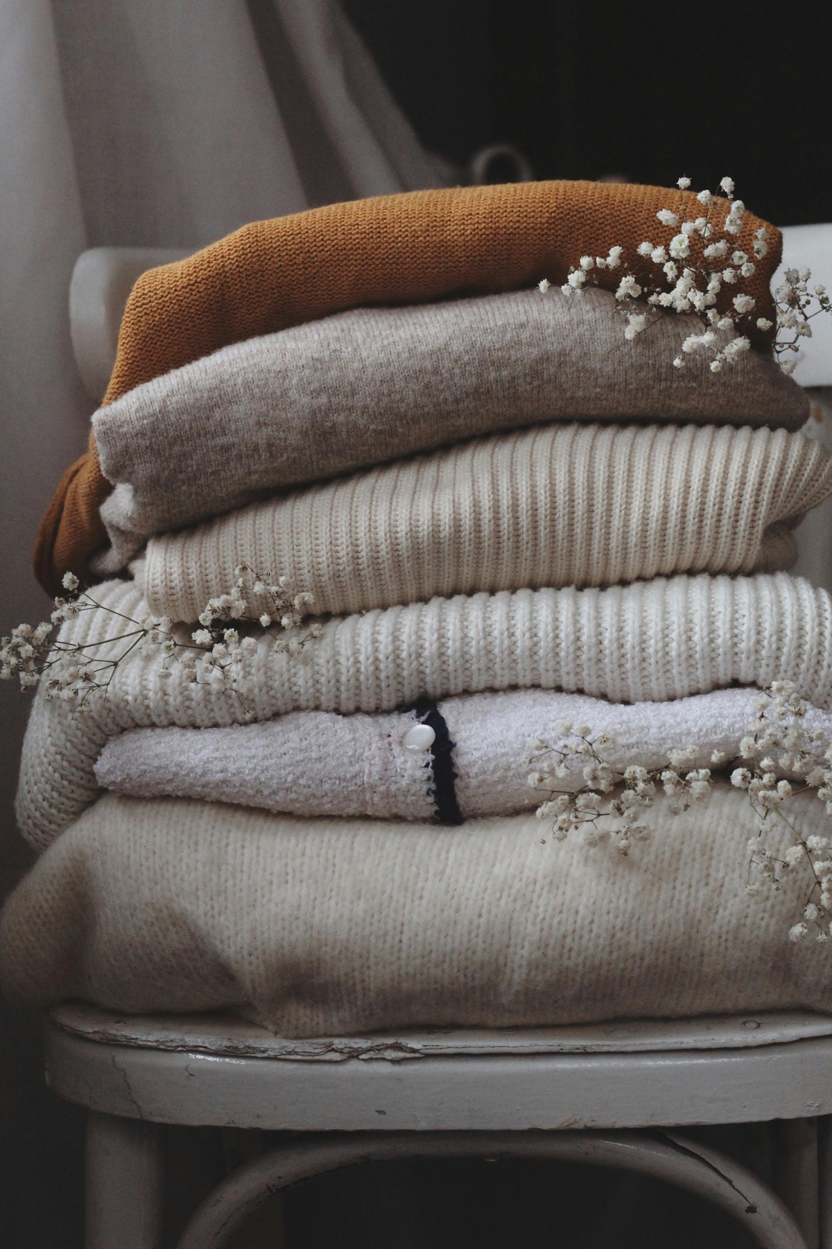 Pile de chandails en laine pliés sur une chaise